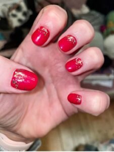 Deep red acrylic gel nails with gold sparkle by Love Pure Beauty